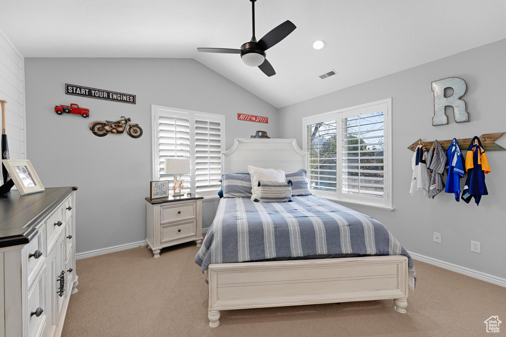 Bedroom featuring a ceiling fan, light colored carpet, visible vents, baseboards, and lofted ceiling