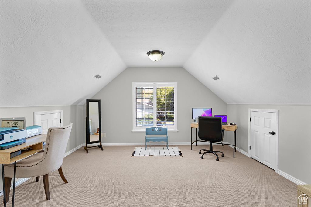Carpeted office with baseboards, lofted ceiling, a textured ceiling, and visible vents