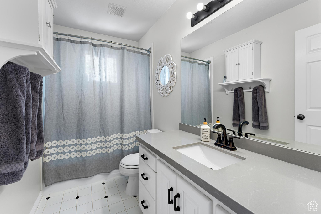 Full bathroom featuring vanity, tile patterned floors, toilet, and visible vents