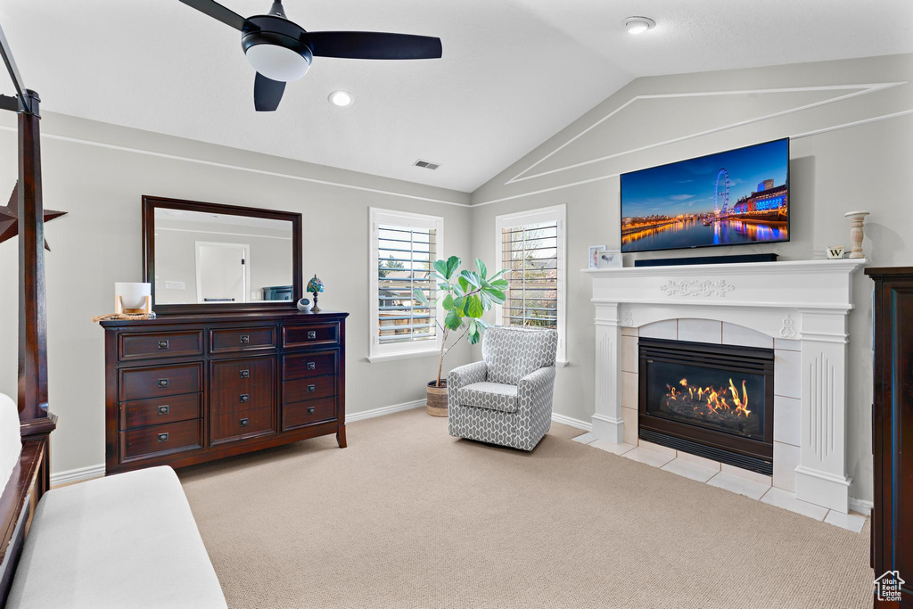 Sitting room featuring light carpet, a ceiling fan, lofted ceiling, a tile fireplace, and visible vents