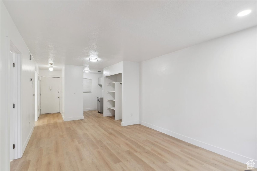 Interior space featuring baseboards, light wood finished floors, and visible vents