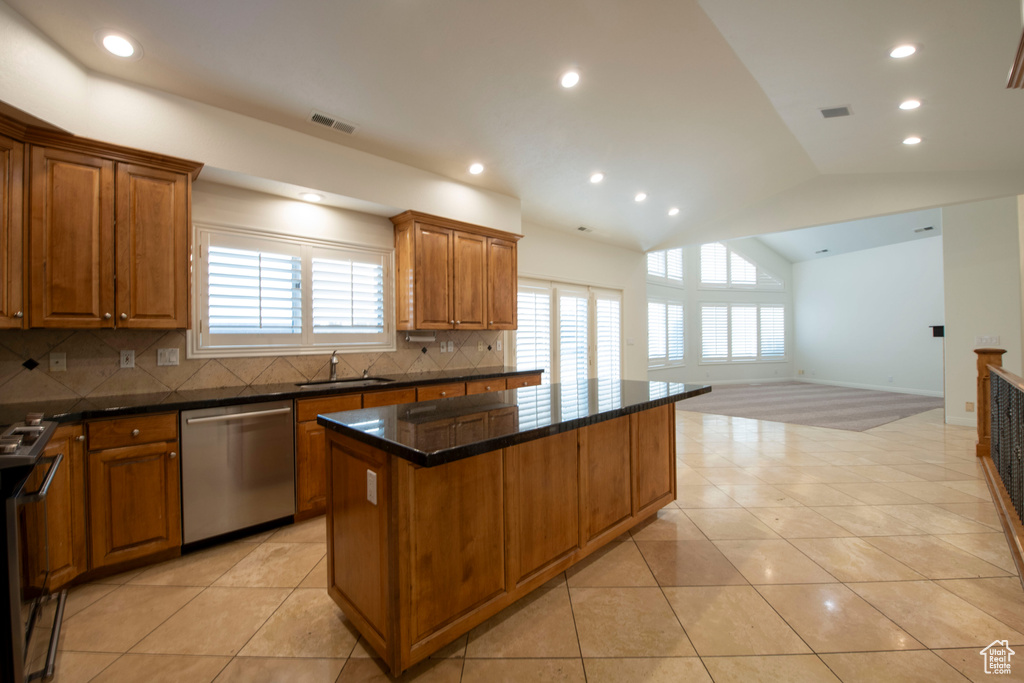 Kitchen with visible vents, decorative backsplash, a kitchen island, a sink, and appliances with stainless steel finishes