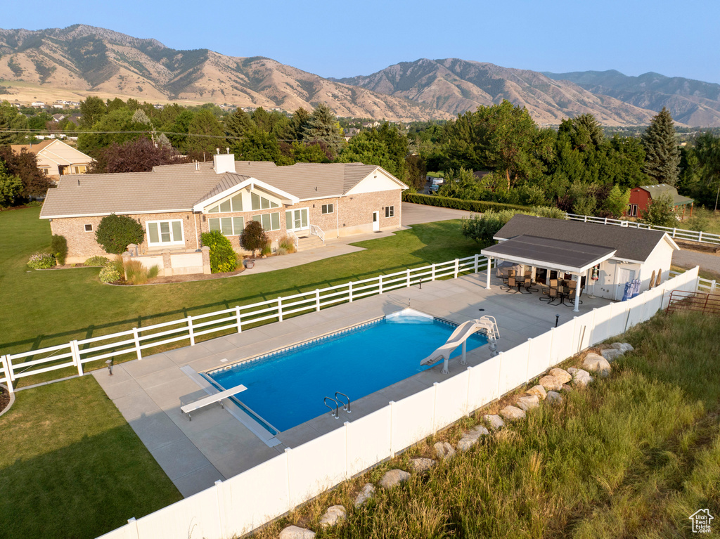 View of pool featuring a lawn, a fenced backyard, a diving board, and a fenced in pool