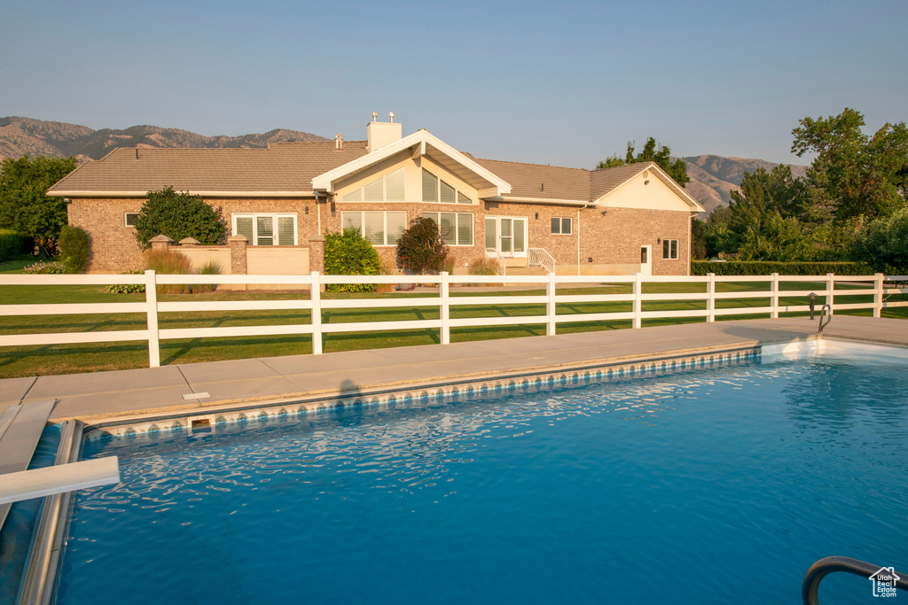 View of swimming pool with a lawn, a fenced in pool, a mountain view, and fence private yard