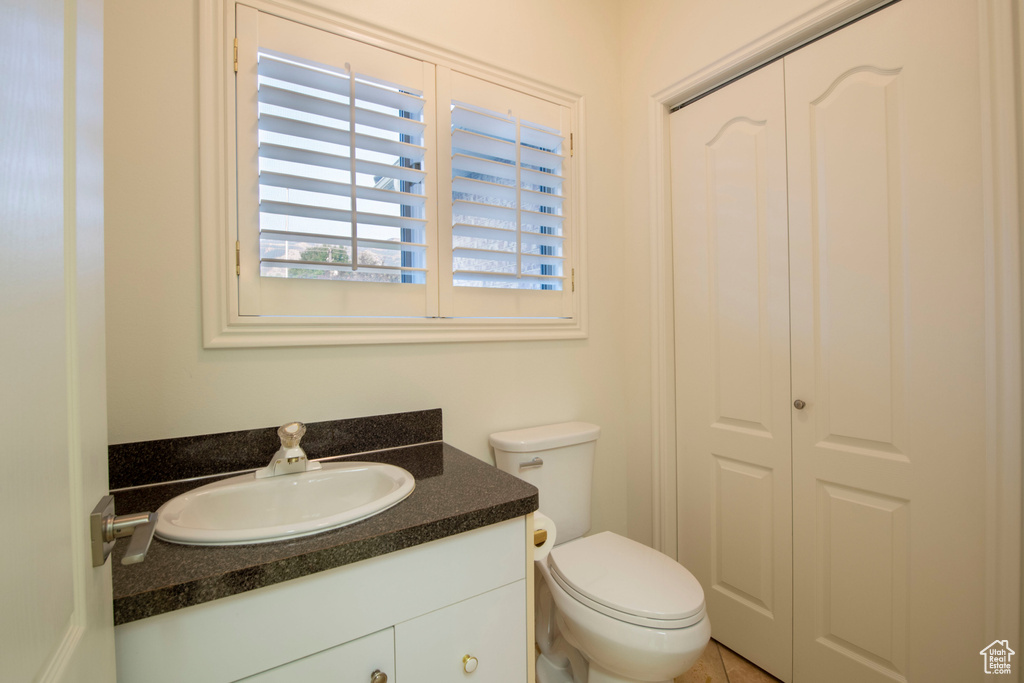 Half bathroom featuring vanity and toilet