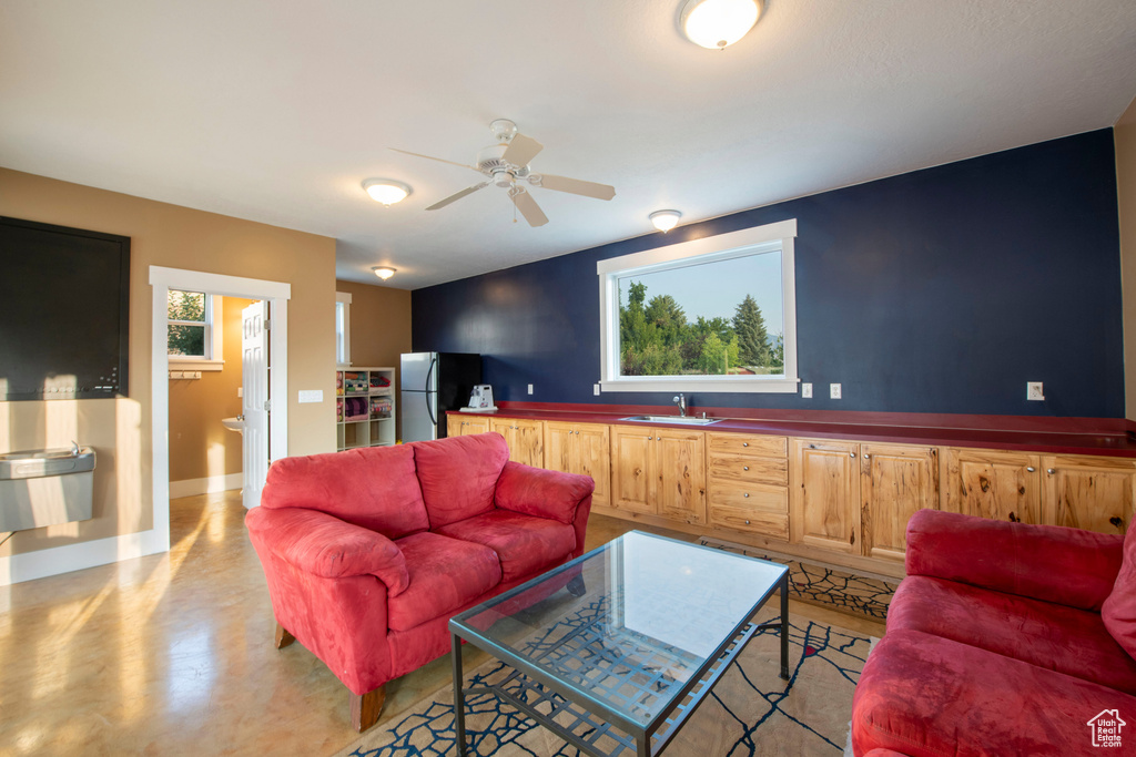 Living area featuring baseboards, concrete floors, and ceiling fan