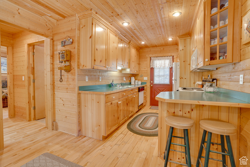 Kitchen featuring white appliances, wooden walls, light wood-style flooring, and wooden ceiling