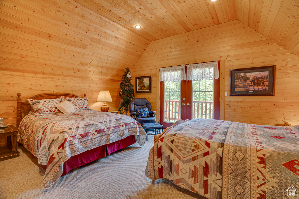 Carpeted bedroom featuring vaulted ceiling, wood walls, wood ceiling, and access to outside