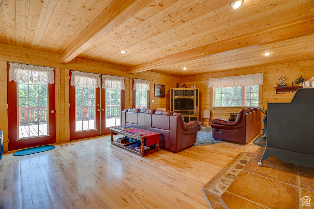 Living room with french doors, wood ceiling, wood walls, and light wood-style flooring