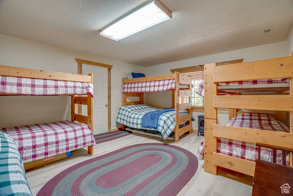 Bedroom with a textured ceiling and wood finished floors