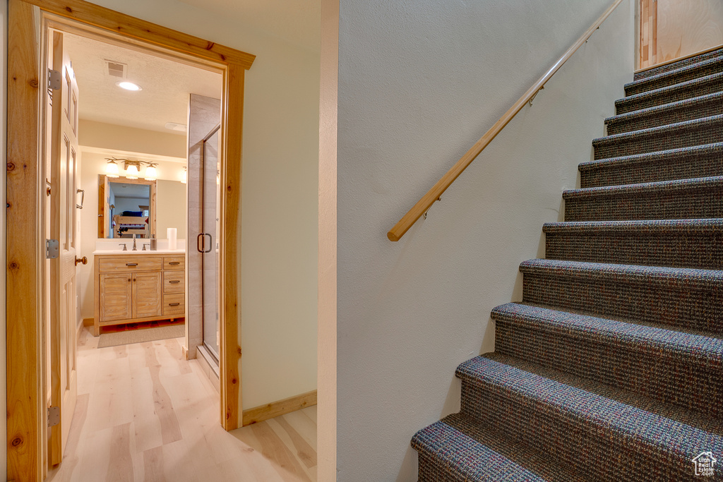 Staircase with visible vents and wood finished floors