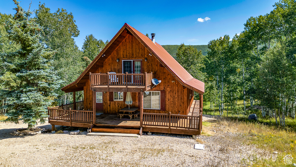 Back of house featuring metal roof and a deck