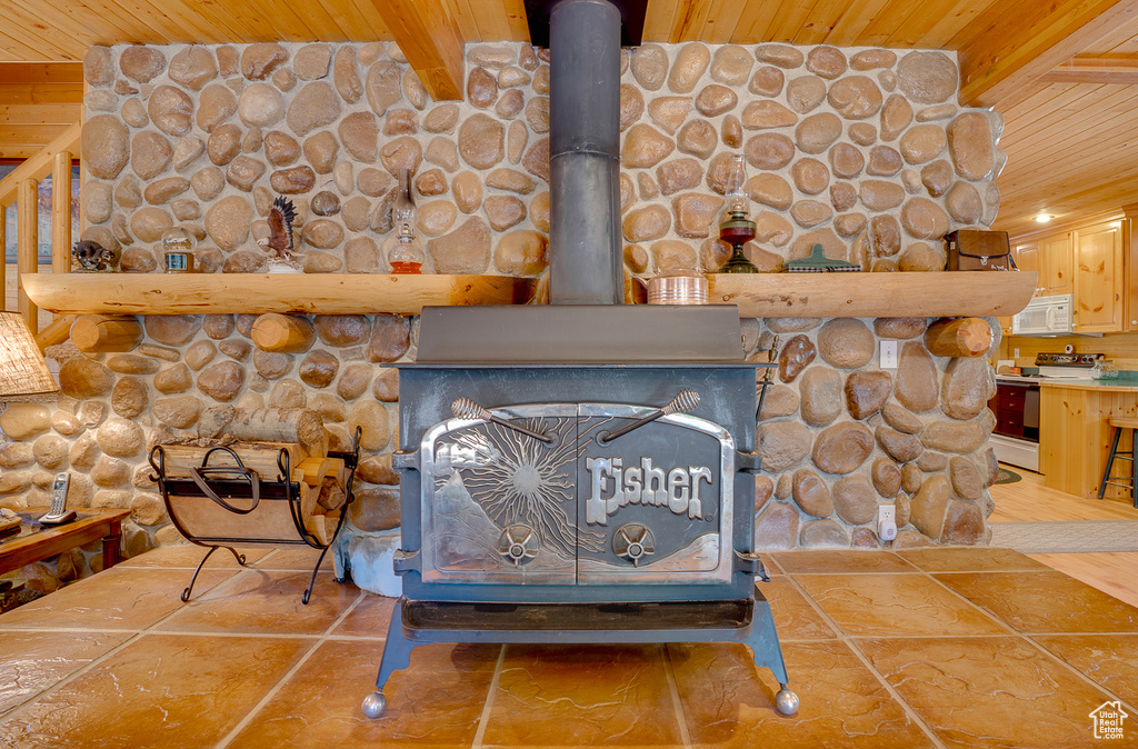 Details featuring white appliances, a wood stove, and wood ceiling