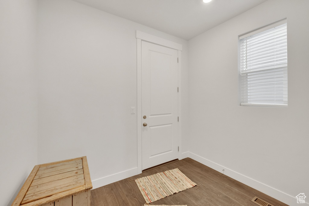 Doorway to outside featuring wood finished floors and baseboards