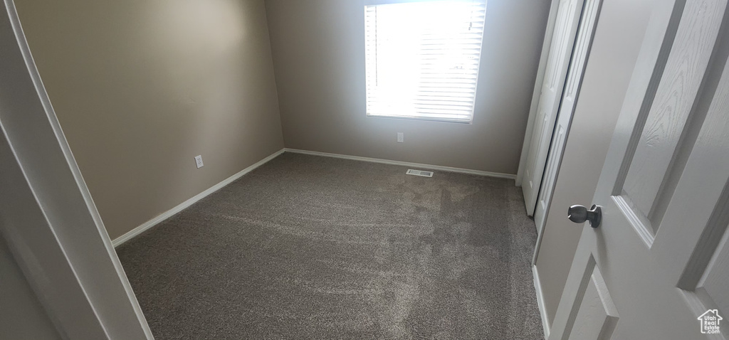 Spare room featuring baseboards, carpet flooring, and visible vents