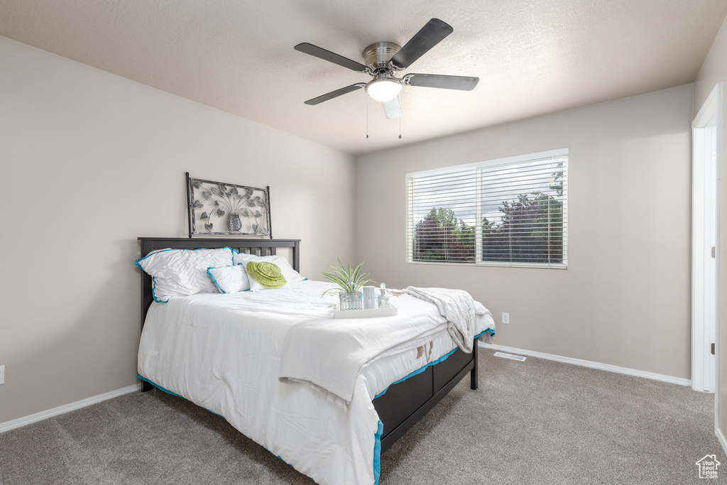 Bedroom with carpet, baseboards, and a ceiling fan