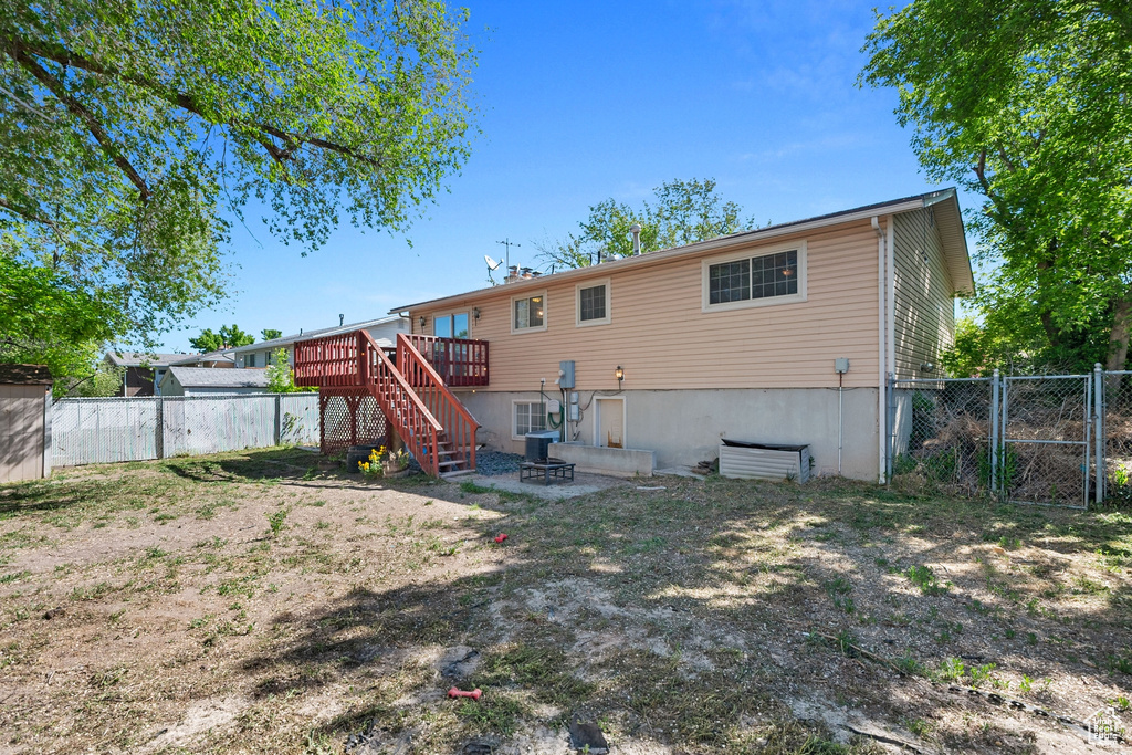 Back of house featuring a gate, stairs, fence, and a deck