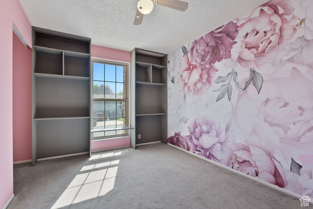 Unfurnished bedroom with baseboards, carpet flooring, ceiling fan, and a textured ceiling