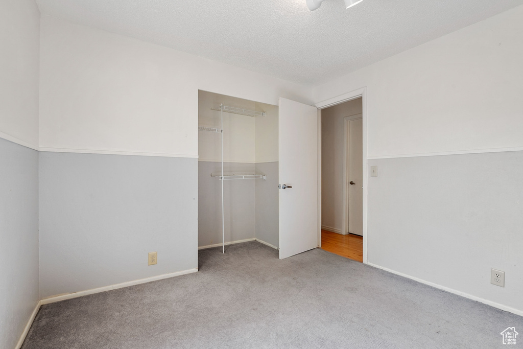 Unfurnished bedroom with carpet, a closet, and baseboards
