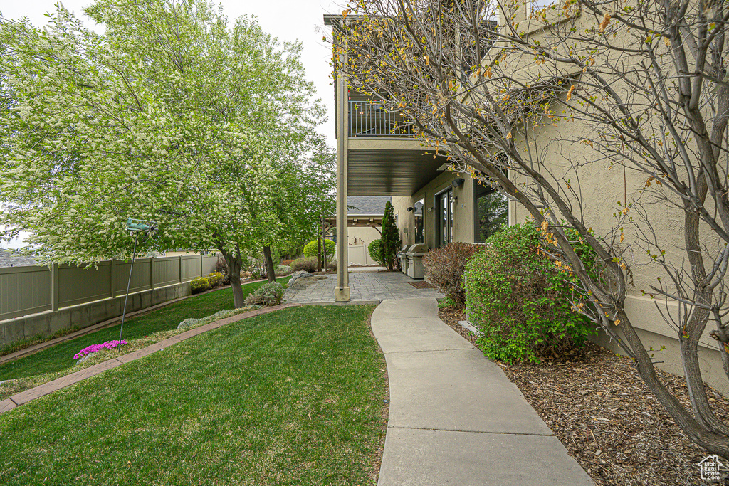 View of yard featuring fence and a balcony