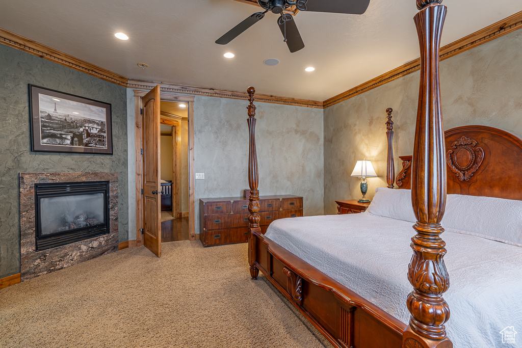 Bedroom with a ceiling fan, a fireplace, light carpet, ornamental molding, and recessed lighting