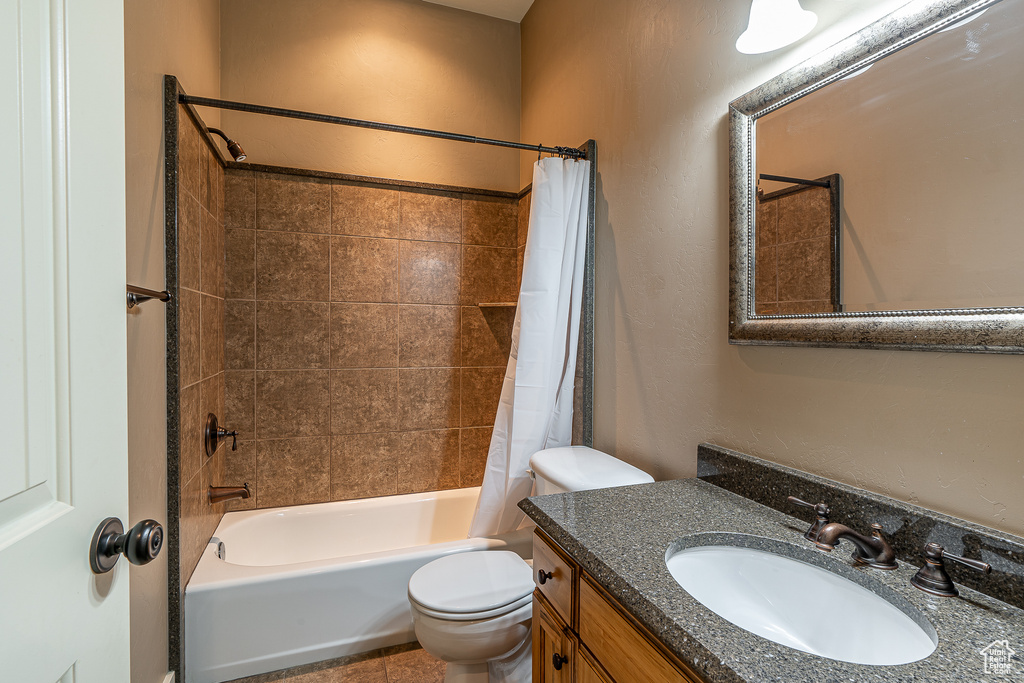 Bathroom with vanity, toilet, and shower / tub combo