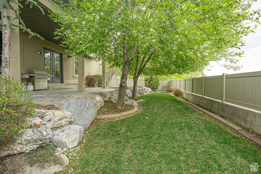 View of yard featuring a patio, french doors, and a fenced backyard