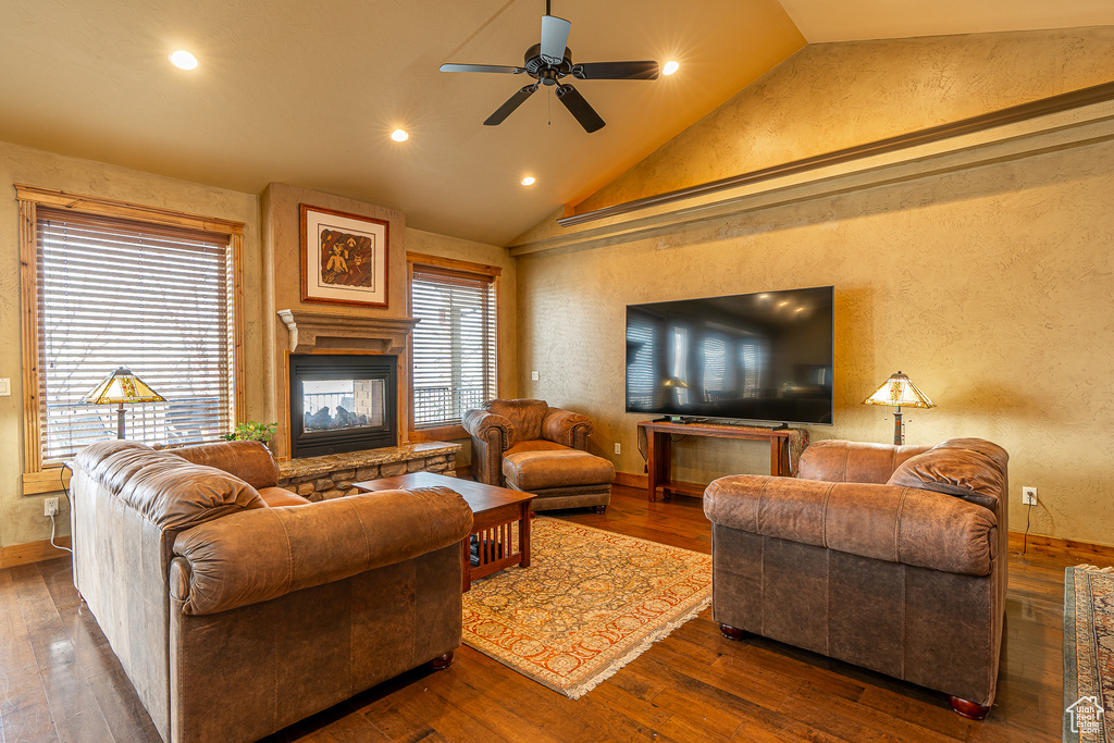 Living area with hardwood / wood-style floors, recessed lighting, a textured wall, a ceiling fan, and a multi sided fireplace