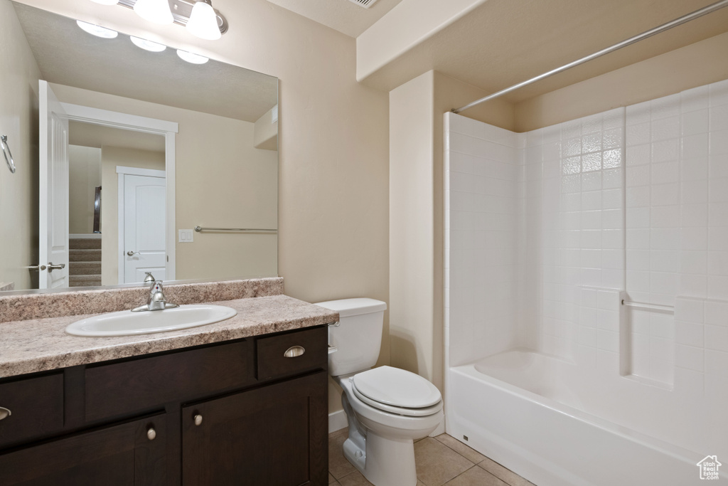 Full bath with tile patterned floors, vanity, toilet, and bathing tub / shower combination