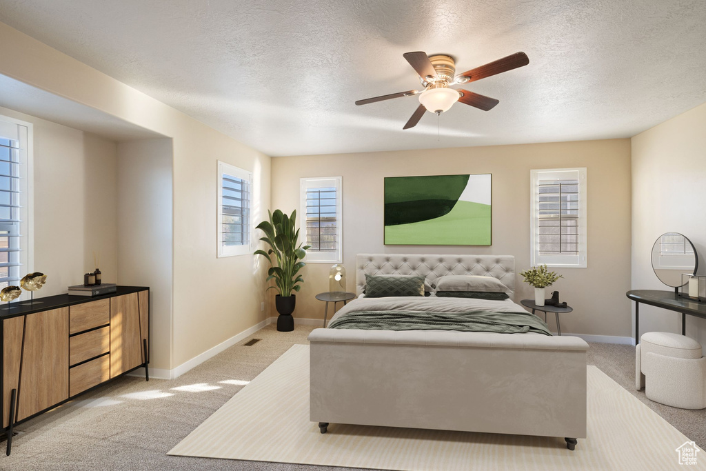 Bedroom featuring baseboards, light carpet, a ceiling fan, and a textured ceiling