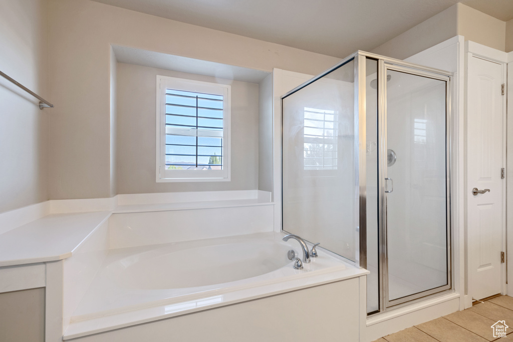Bathroom featuring tile patterned flooring, a bath, and a stall shower