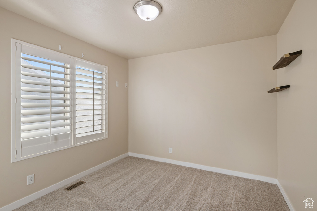 Carpeted spare room with baseboards and visible vents