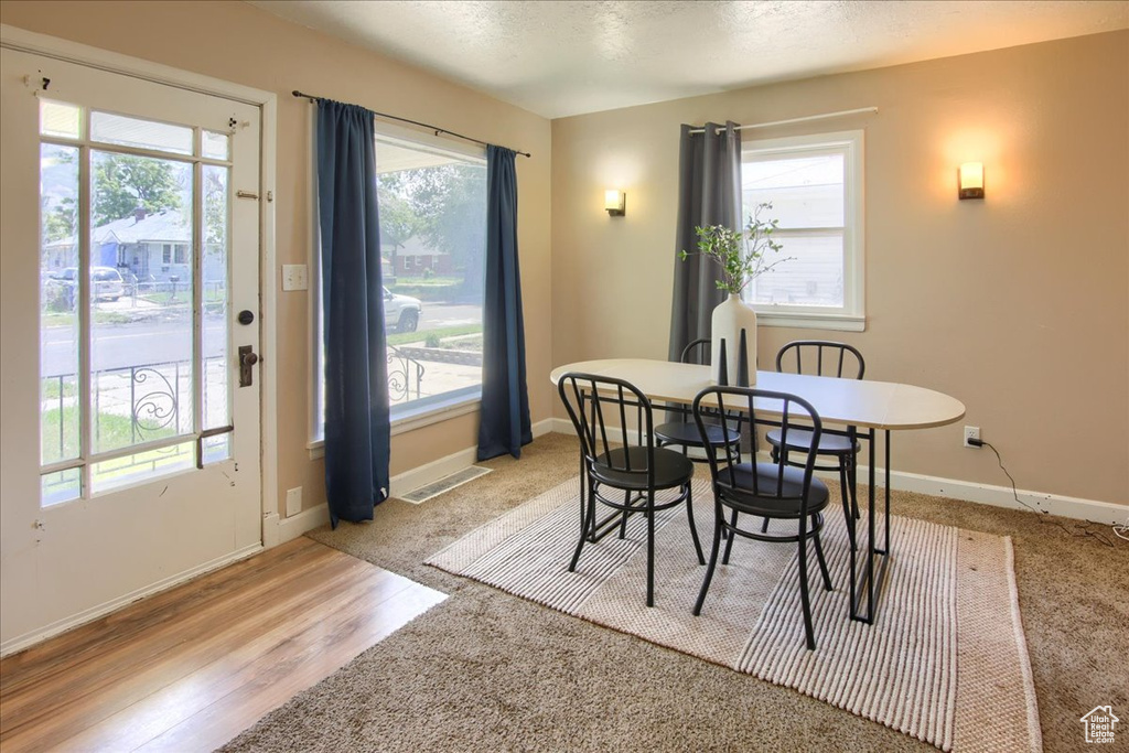 Dining area featuring healthy amount of natural light, baseboards, and light wood-type flooring