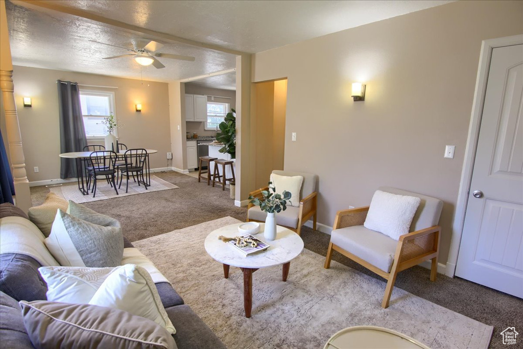 Living room featuring carpet floors, a ceiling fan, and baseboards