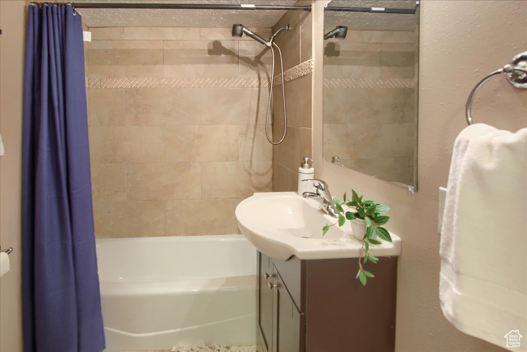 Bathroom featuring vanity and shower / tub combo with curtain