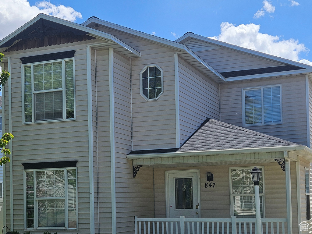 View of front of property featuring a porch and a front yard