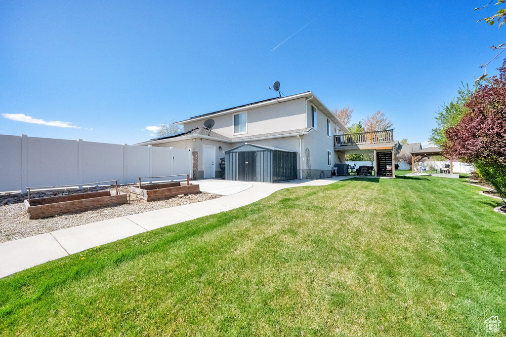 Back of property featuring a vegetable garden, a yard, stairway, and fence