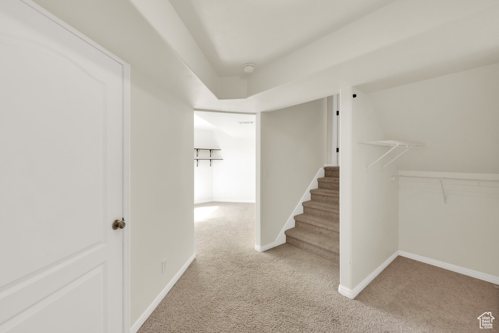 Corridor featuring carpet, stairway, and baseboards