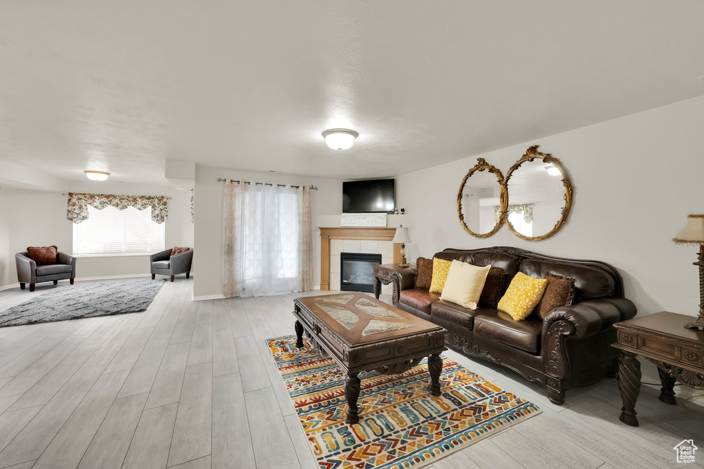 Living area featuring baseboards, a fireplace, and light wood-style flooring