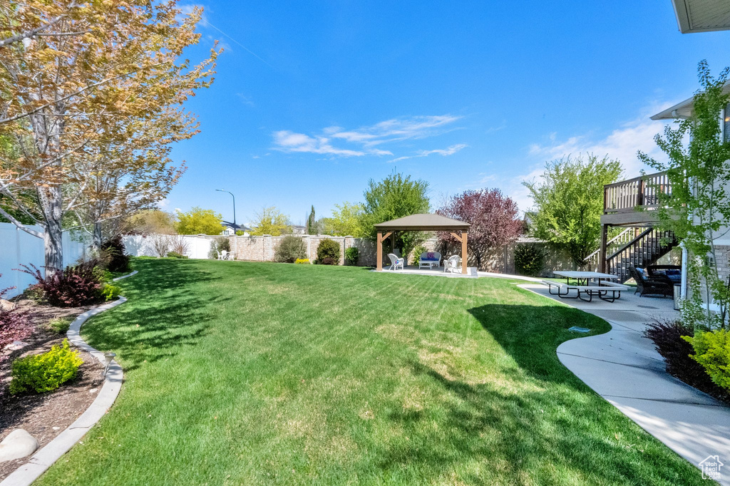 View of yard with a patio, stairs, a gazebo, and a fenced backyard