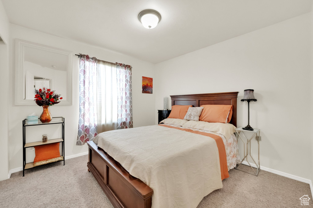 Bedroom with baseboards and light carpet