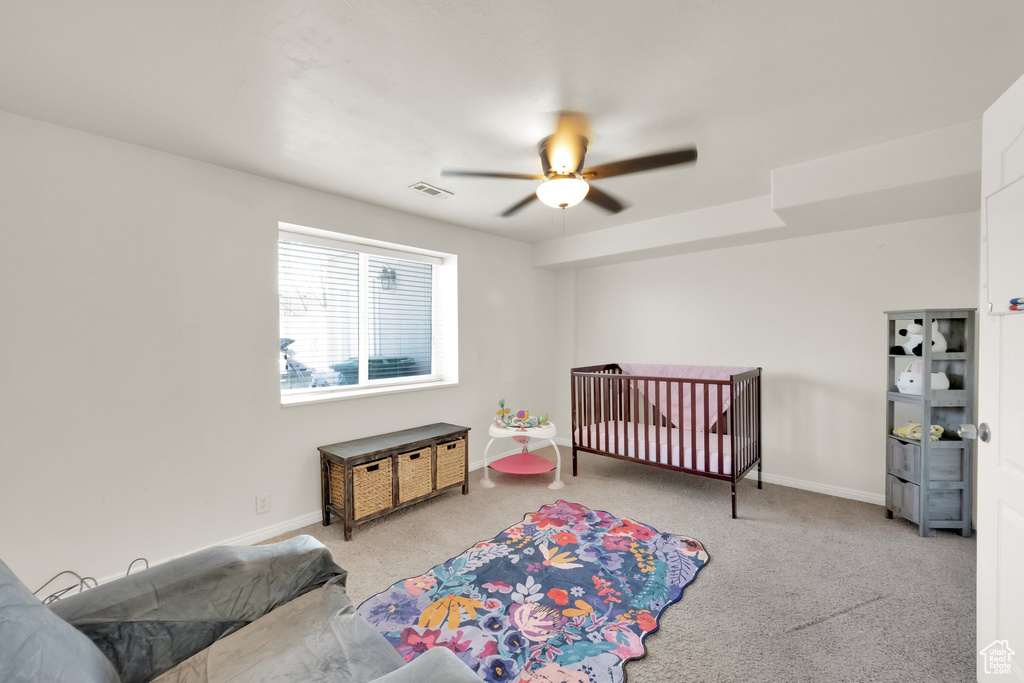 Carpeted bedroom with visible vents, a ceiling fan, and baseboards