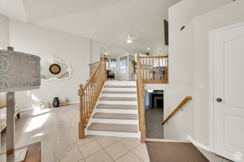 Staircase featuring ceiling fan, tile patterned flooring, and baseboards