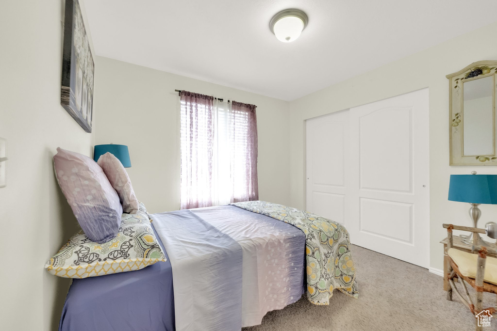 Bedroom featuring carpet and a closet