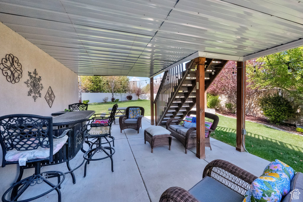 View of patio featuring outdoor lounge area, a fenced backyard, outdoor dining area, and stairs