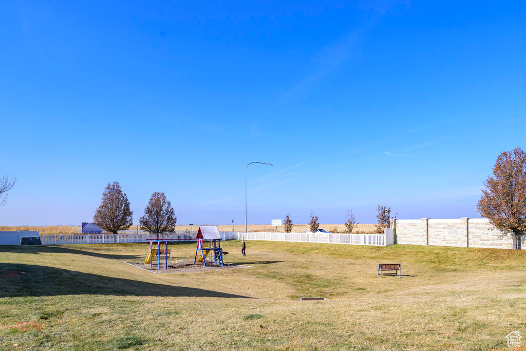 Community play area featuring a yard and fence