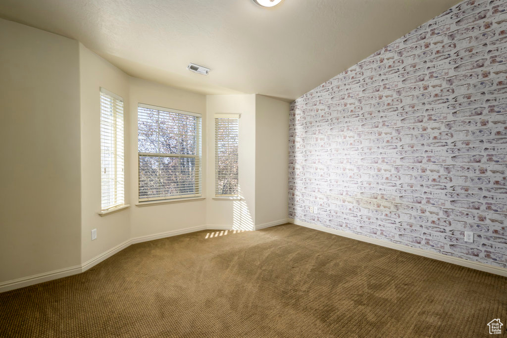 Unfurnished room with baseboards, visible vents, and carpet