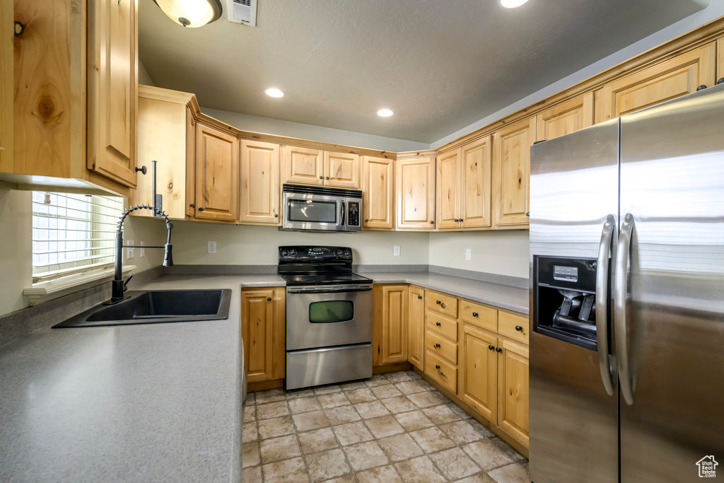 Kitchen with a sink, stone finish floor, visible vents, appliances with stainless steel finishes, and recessed lighting