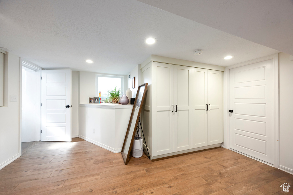 Interior space with light wood finished floors, baseboards, and recessed lighting