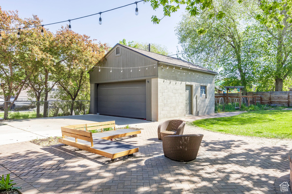 Garage with concrete driveway and fence